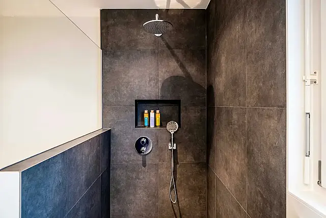 Banheiro com chuveiro italiano: ausência de box de vidro, piso contínuo e espaço integrado.