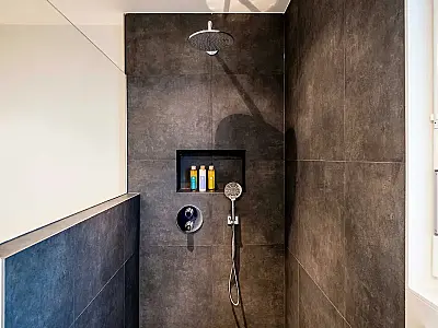 Banheiro com chuveiro italiano: ausência de box de vidro, piso contínuo e espaço integrado.