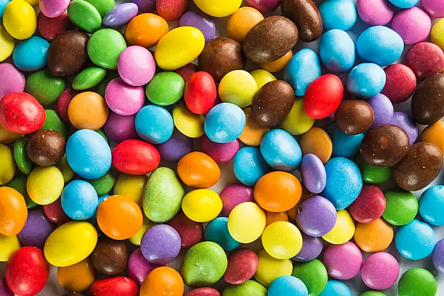 Conheça os bastidores dos M&M's: da criação na Guerra Civil Espanhola ao processo industrial das cascas coloridas que não derretem na mão.