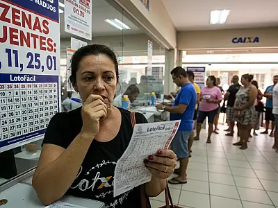 Apostador confere volante da Lotofácil em busca do prêmio milionário.