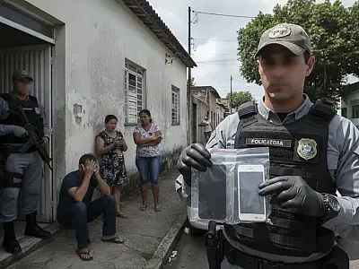 Agentes da Polícia Federal durante operação contra crimes cibernéticos em Niterói, Rio de Janeiro.