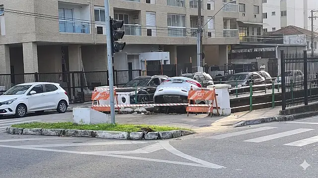 Veículo prata ficou equilibrado na mureta do Canal 5, atraindo olhares de moradores e turistas em Santos.