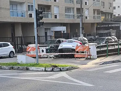 Veículo prata ficou equilibrado na mureta do Canal 5, atraindo olhares de moradores e turistas em Santos.