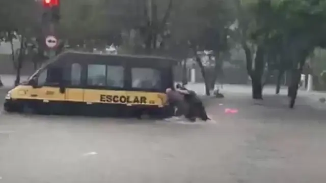 Van escolar é resgatada de enchente em São Paulo.
